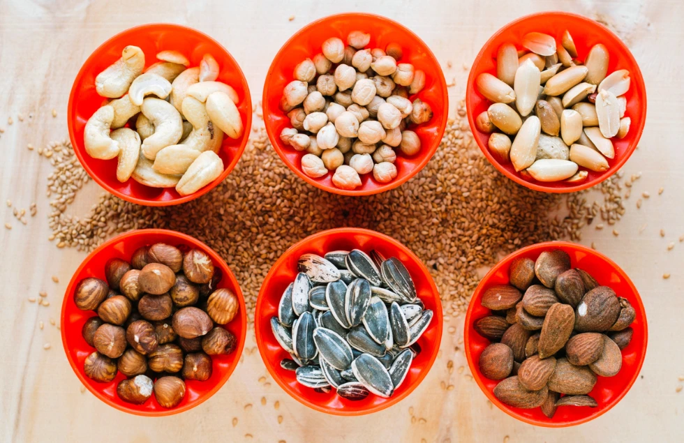 6 red bowls filled with nuts and seeds