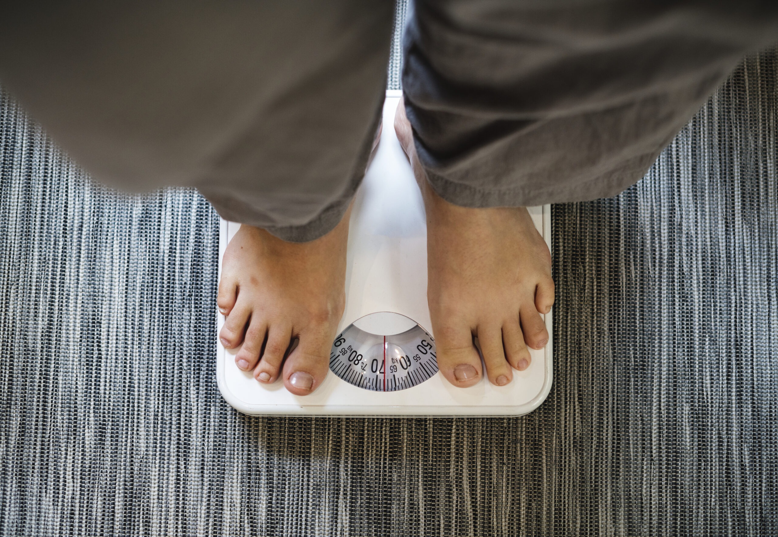 Woman checking weight gain linked to hormonal changes during perimenopause